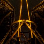 A telescope silhouetted against a starry night sky
